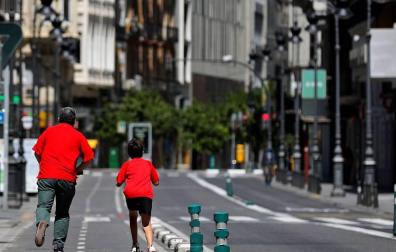 Un niño y un adulto, en una calle de Valencia.