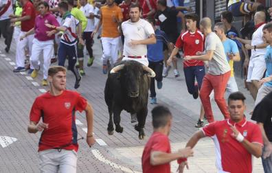 Unos mozos corren delante de un toro durante el último encierro de San Sebastián de los Reyes.