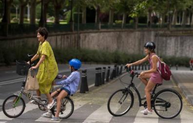 Varias personas cruzan un paso de peatones en bici en Pamplona.
