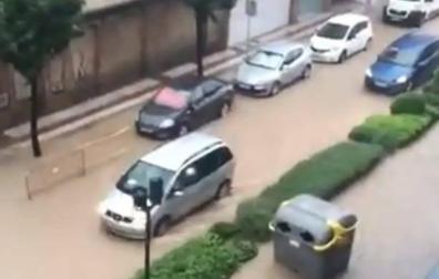 Una calle de Tudela inundada, con un contenedor arrastrado por la fuerza del agua