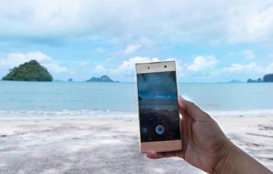 Foto de persona haciendo foto con el móvil en una playa