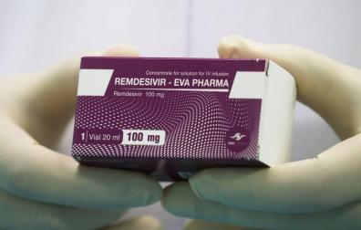 Un técnico de laboratorio sostiene una caja de remdesivir.