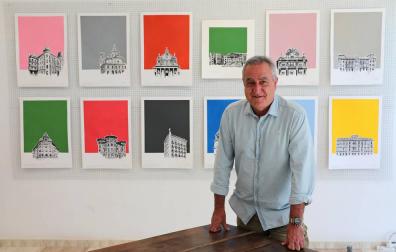 Iñaki Pardos posa junto a algunas de sus obras de fondos coloristas sobre edificios emblemáticos y reconocibles de Pamplona.