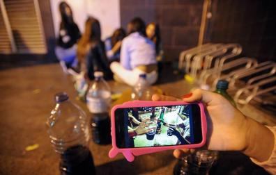 Un grupo de adolescentes hace botellón en la calle.