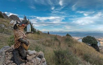 Estatua del cocodrilo que apareció hace unos días en la cima de Montejurra, sujetando con la mano la botella de cava.