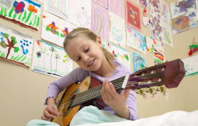 Una niña toca la guitarra en una clase.