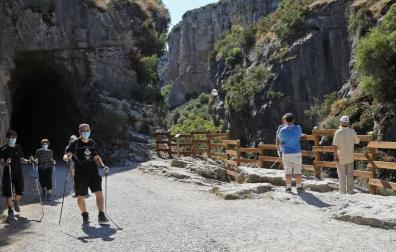 Diversos grupos de senderistas recorren, con la mascarilla puesta, la foz de Lumbier, uno de los atractivos naturales de la villa.