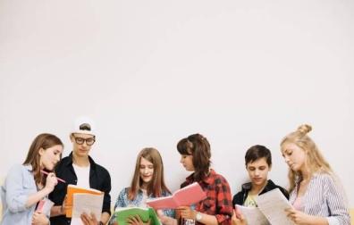 Imagen de varios estudiantes repasando sus apuntes antes de un examen
