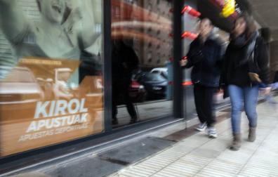 Dos personas pasan delante de una casa de apuestas.