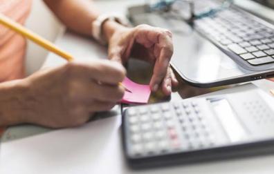 Imagen de una persona manejando documentación y una calculadora