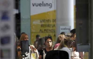 Personal de facturación de Vueling atiende a los viajeros en el Aeropuerto de El Prat.