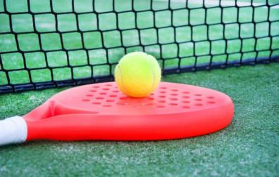 Imagen de una raqueta de pádel junto a una pelota