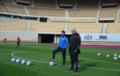 Rafa Tubío, a la izda pisando un balón en la sesión del Tomares en La Cartuja, escenario del duelo. A su lado, Antonio González, director deportivo.