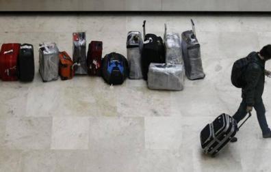 Pasajero traslada su maleta tras recogerla de la cinta transportadora del aeropuerto de Barajas.