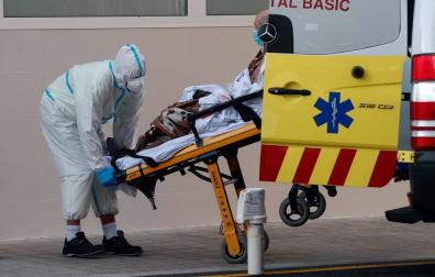 Un sanitario traslada a un enfermo de coronavirus en el Hospital Clínico de Valencia.