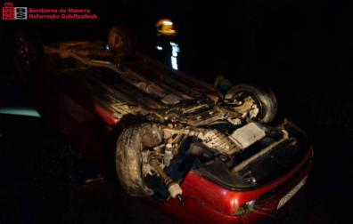 Los bomberos, junto al vehículo accidentado.
