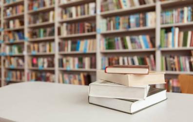 Imagen de varios libros sobre el mostrador de una librería