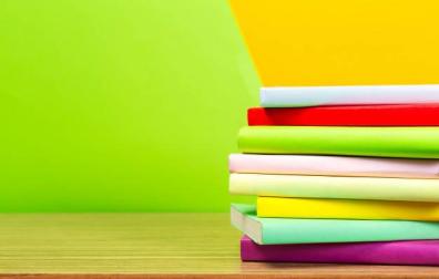 Imagen de varios libros de colores apilados en una mesa