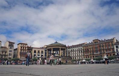 Viadantes cruzan poco antes del mediodía de ayer por la plaza del Castillo.