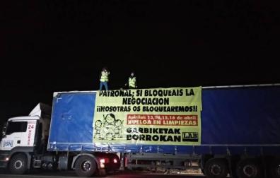 Dos trabajadoras de limpiezas se sube a un camión en protesta por el convenio