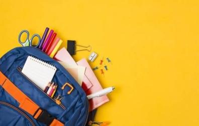 Imagen de una mochila junto a varios artículos de material escolar