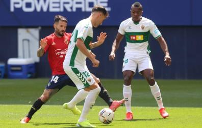 Rubén García pelea por un balón con dos rivales del Elche.