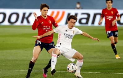 El defensa del Real Madrid, Álvaro Odriozola, intenta controlar el balón ante el centrocampista de Osasuna, Javi Martínez.