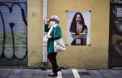 Una mujer pasea con mascarilla por el Casco Antiguo de Pamplona en Jueves Santo.