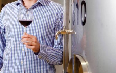 Una persona, con una copa de vino de Rioja.