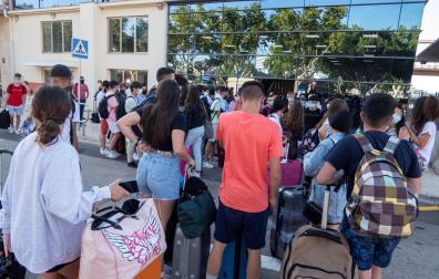 Varios estudiantes que se encontraban en cuarentena por el macrobrote de covid-19 en Mallorca aguardan a su llegada a la estación marítima para embarcar hacia Valencia