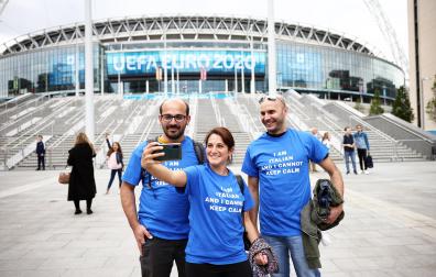 Aficiondos italianos se fotografían delante del estado de Wembley en la víspera de la final entre Inglaterra e Italia