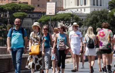Turistas caminan por la Via del Foro Imperial en Roma