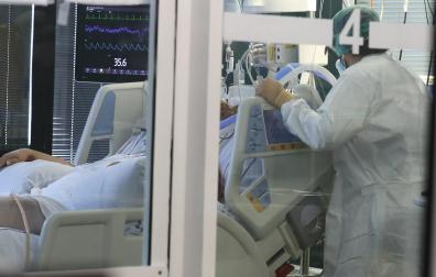 Una profesional sanitaria atiende a una persona ingresada en la UCI en el complejo hospitalario Insular Materno Infantil de Las Palmas de Gran Canaria