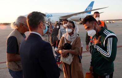 El ministro de la Presidencia, Félix Bolaños, da la bienvenida a la jugadora afgana de baloncesto en silla de ruedas Nilofar Bayat y a su marido a su llegada a la base aérea militar de Torrejón de Ardoz