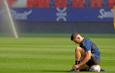 David García se ata las botas para comenzar el entrenamiento de ayer en El Sadar a puerta cerrada.