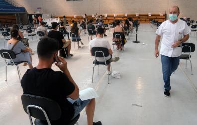 Varias personas esperan tras vacunarse en julio en el polideportivo de la UPNA