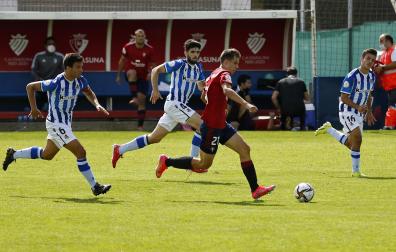 El jugador del Promesas Ander Yoldi conduce el balón ante la presencia de Julen Zubillaga y Kerman Sukia