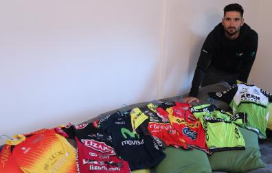 Enrique Sanz, este lunes por la tarde en su casa de Orkoien, con todos los maillots que ha vestido desde juvenil hasta profeisonal en los últimos 16 años