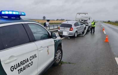 Imagen de un coche de la Guardia Civil junto al vehículo implicado en el accidente.