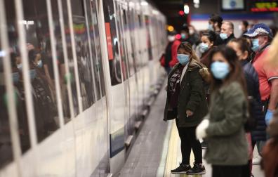 Viajeros con mascarillas en un andén de la estación de metro de Nuevos Ministerios en Madrid