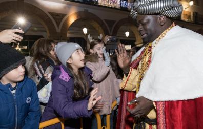El Rey Baltasar saluda a un grupo de niños y niñas durante la última cabalgata, la de 2020
