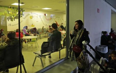 Café en mano, Stela Tsiolakki aguarda al turno que le corresponde a su hijo, mientras contempla una sala de espera saturada