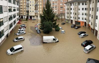 Aspecto que presentaba en la mañana de ayer la plaza de Larrainzar de Burlada. Vehículos afectados por la crecida del río