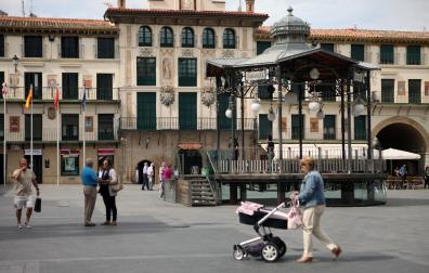 Varias personas pasean junto al quiosco de la plaza de los Fueros, centro neurálgico de Tudela