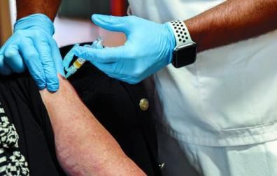 Una mujer recibe la vacuna de la gripe