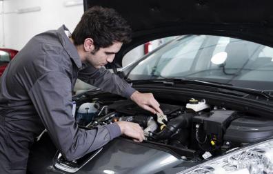 El operario de un taller realiza un trabajo en un coche