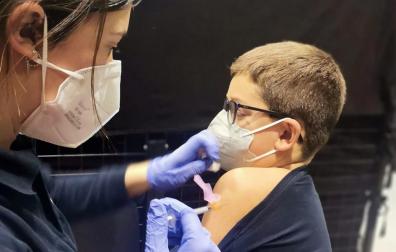 Una sanitaria inocula  a un niño una de las dosis de la vacuna contra el coronavirus en Tafalla