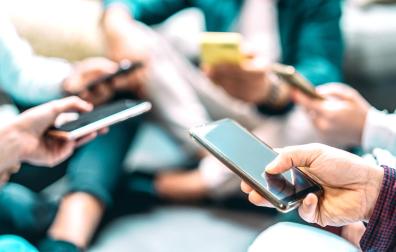 Un grupo de personas usan su teléfono móvil