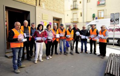 Representantes de todas las entidades implicadas en la campaña posan con los tuppers tras la presentación en el mercado de Tafalla