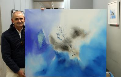 El artista Antonio Peña posa en la galería Michel Menéndez junto a la obra titulada Destrucción azul I.